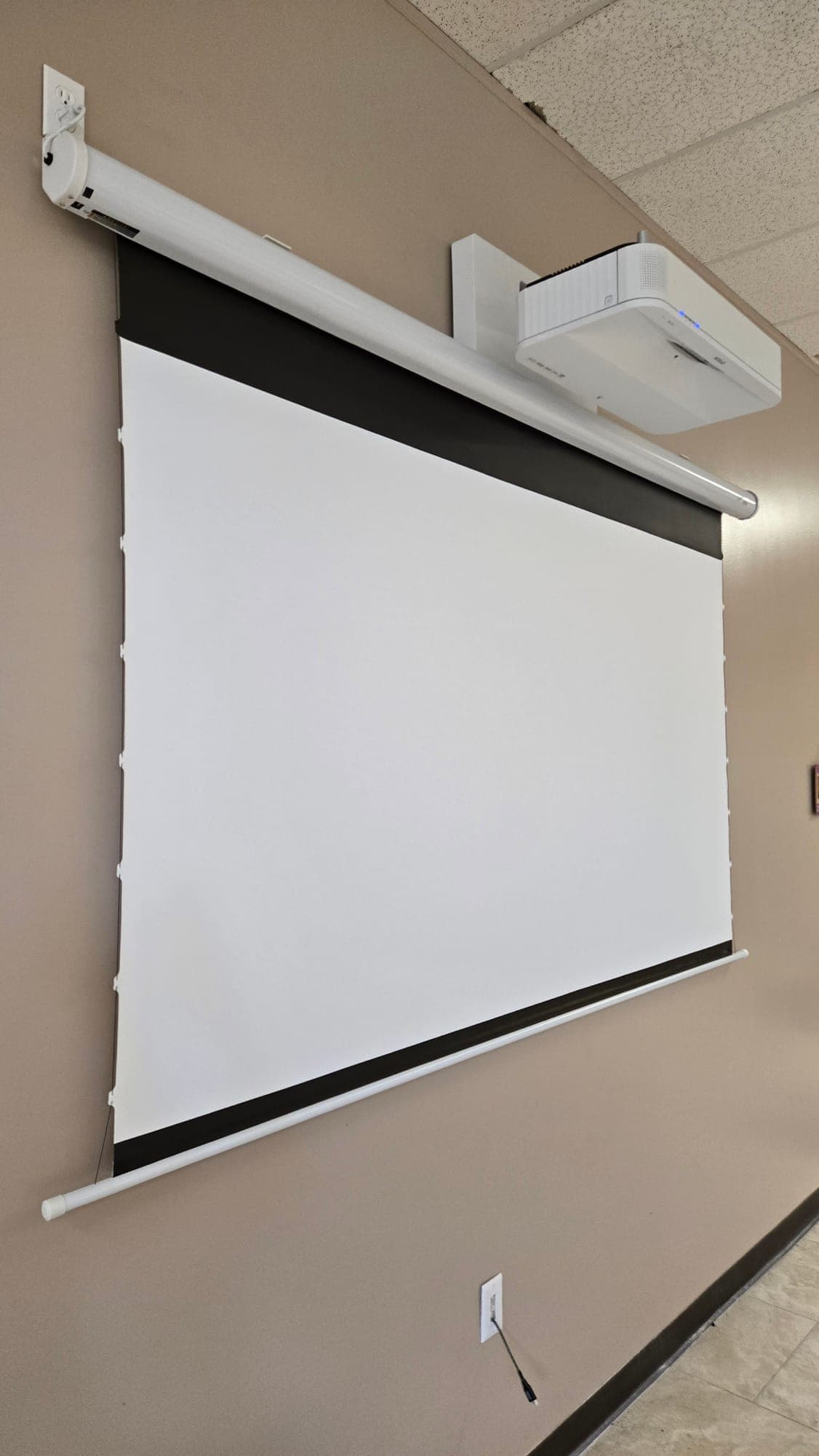 Motorized projection screen and projector in a commercial space