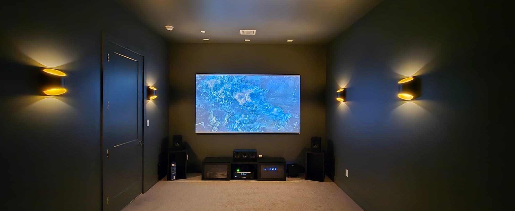 Dedicated home theater with surround speakers and a projection screen