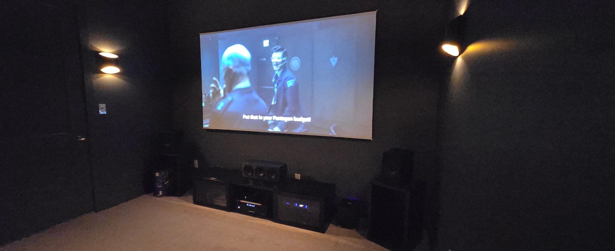 Home theater playing a film on a large projection screen