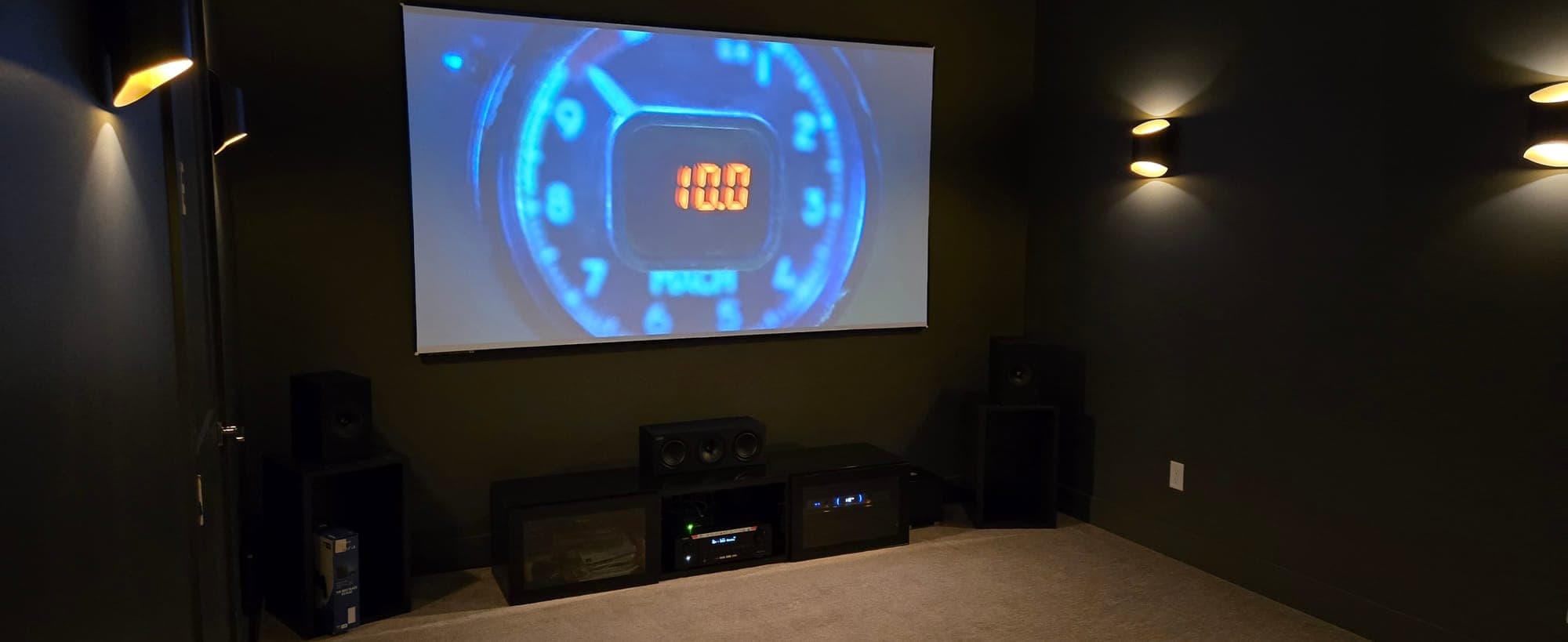 Home theater with a center channel and subwoofers below the screen