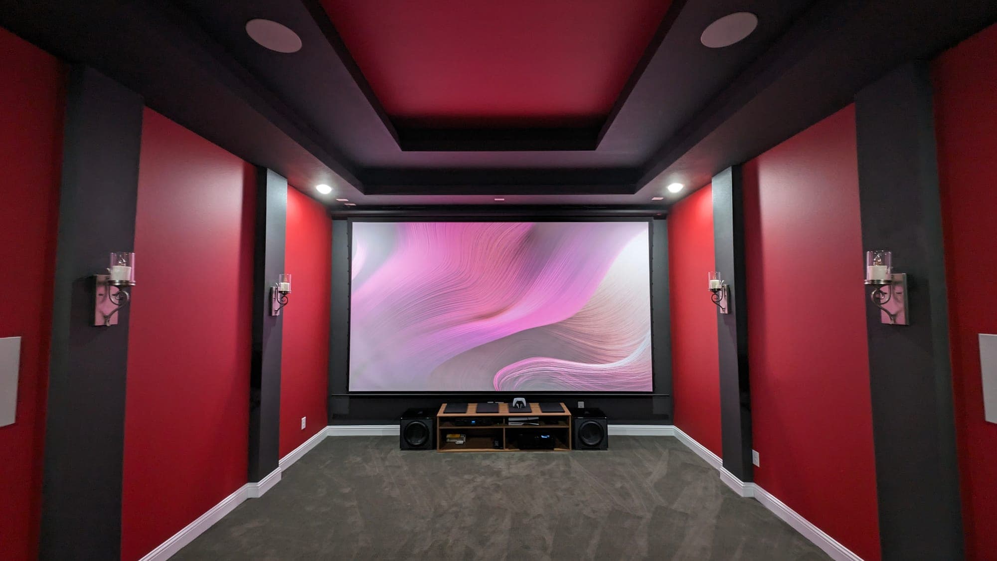 Red home theater with acoustic panels and a projection screen