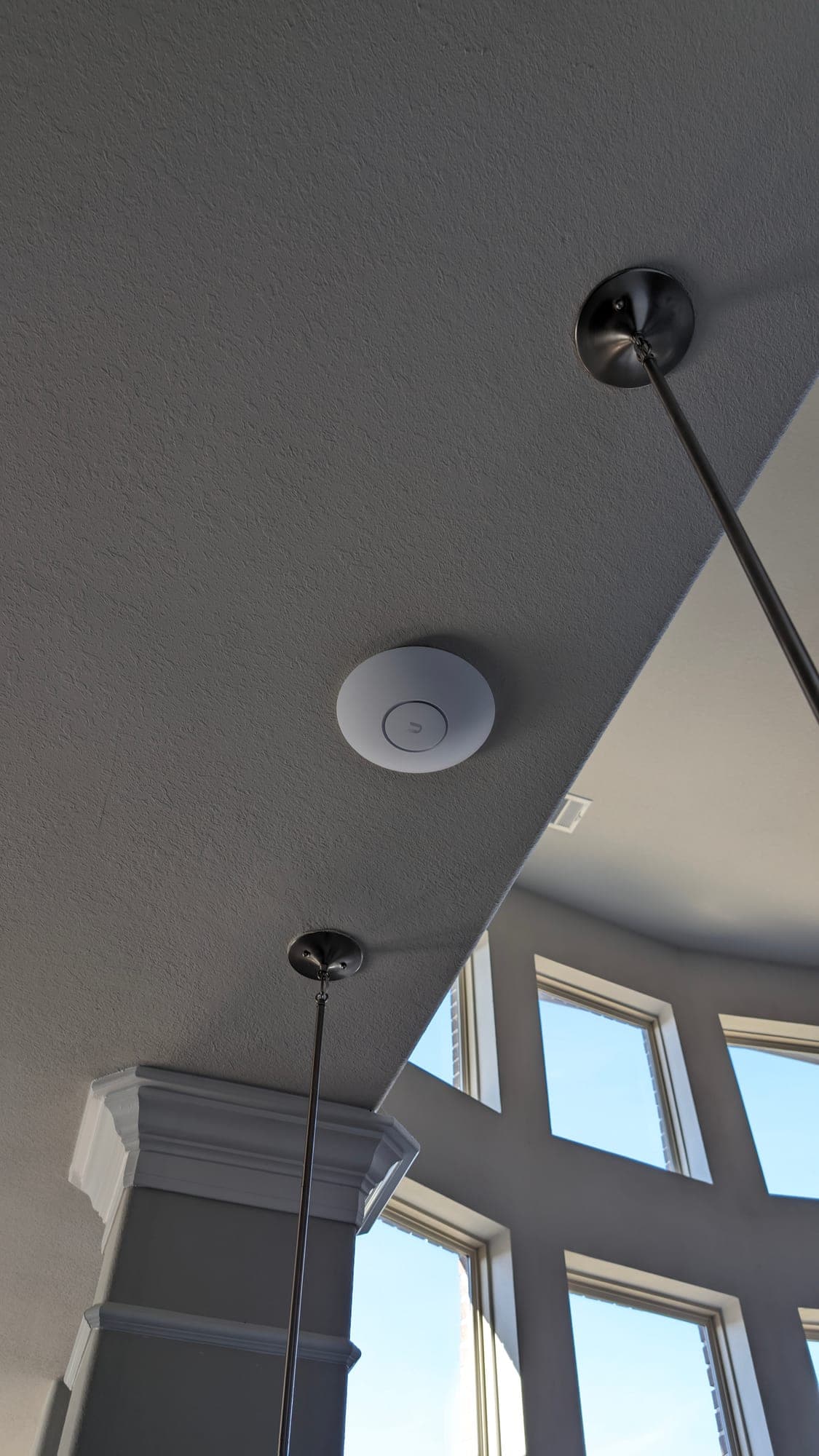 Ceiling-mounted Ubiquiti wireless access point installed on a vaulted ceiling